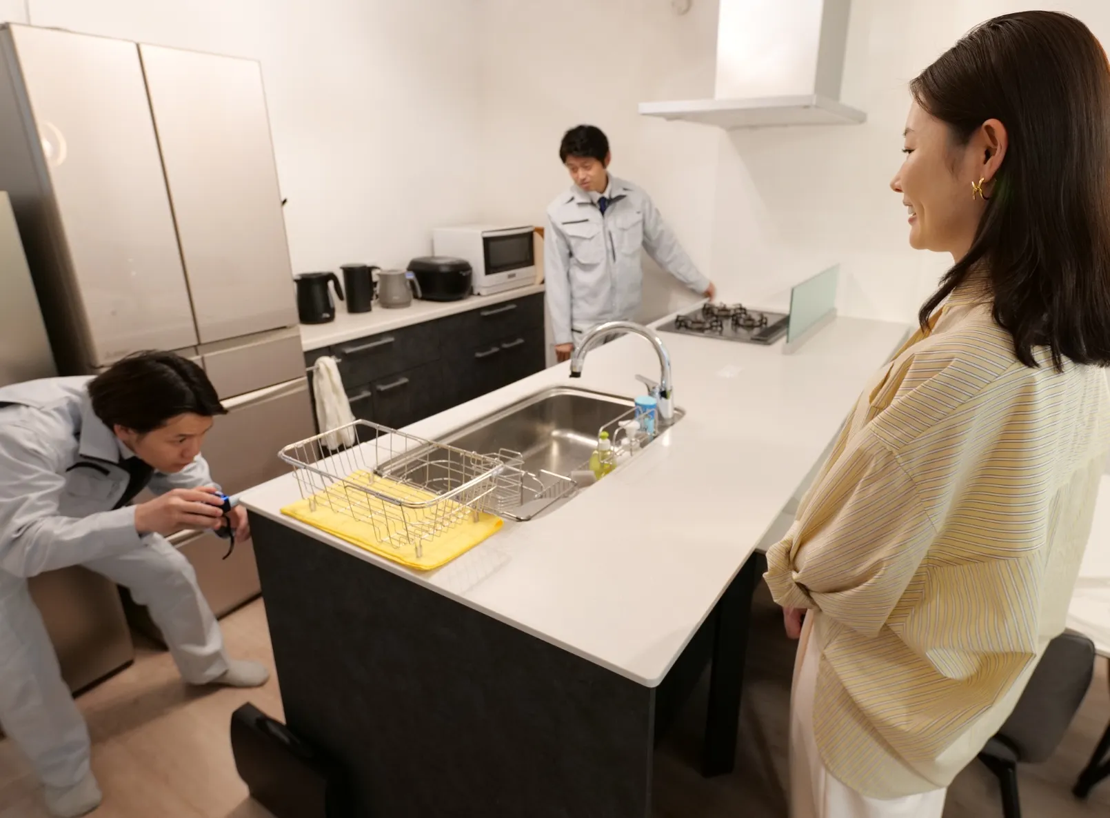 お客様の住まいで水回り設備について説明するスタッフ